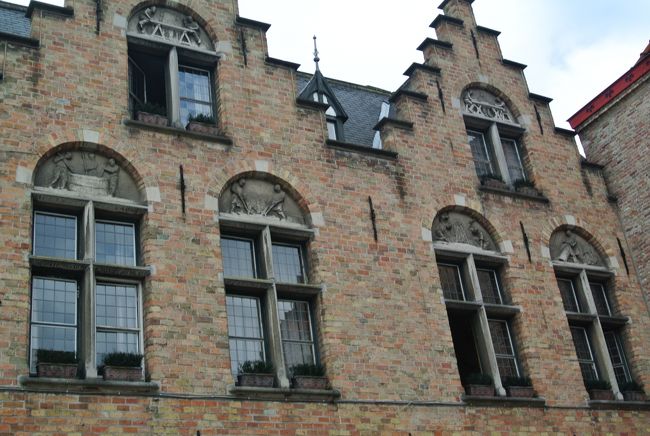 ギルドハウスの1例。<br /><br />窓上、半円形の飾りにレリーフで職場説明あり。