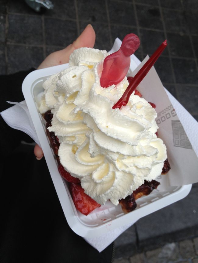 で、ベルギーワッフルいただきました。<br /><br />見本のワッフルがたくさんあるので、指差しでこれをチョイス。<br />いちごと生クリーム。<br /><br />ワッフル自体が十分美味しいので、こんなクドいトッピングしてあるもの選ばなければよかったです(>_<)しまったー！<br />5.5ユーロ。<br /><br />ワッフルはかりっしていて香ばしかったです♪これはシンプルにお砂糖だけで食べるのが一番美味しいと思います！！！<br />お味もお値段もシンプルがいちばん！<br />(ワッフル屋さんはどこも大きく１€の看板が出てました。おそらくワッフル単体が１€、トッピングをすると値段が上がるっぽい)<br /><br /><br />お店は通りに何件もありました★<br /><br />みなさん食べ歩きしています。甘い香りがそこら中でします♪<br /><br />･･･さて、まだ到着して１時間そこらなのに目的１〜３全て達成してしまいました！<br /><br />ここからゆっくりブリュッセルの街を散歩します♪