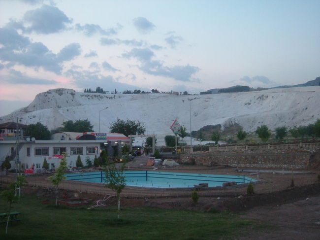 さっそく温泉棚の下にある公園へ散歩に出るが、ホテルの前で２５リラの日没ツアーに参加しないかとお誘いがあった。じゃー値段が値段なので、申し込みして公園に向かう。向かうと言ってもほんの５分もかからない。公園は立派に整備されていて、温泉棚のすぐ下まで柵もないので行ける。池に棚が映りなかなか良い景色だ。日没ツアーは話にならないほどつまらなかった。ただ単にサンセットであり、パムッカレらしい景色ではなかった。絶対に行くなと申し上げたい。ただ地理上には石灰棚や、ヒエラポリスや、カラハユット温泉の位置関係はよく解った。懲りずに明日の１日ツアー(６０リラ）に申し込む。彼の言うには見どころ各地の入場料だけで上まってしまうよの一言で。。