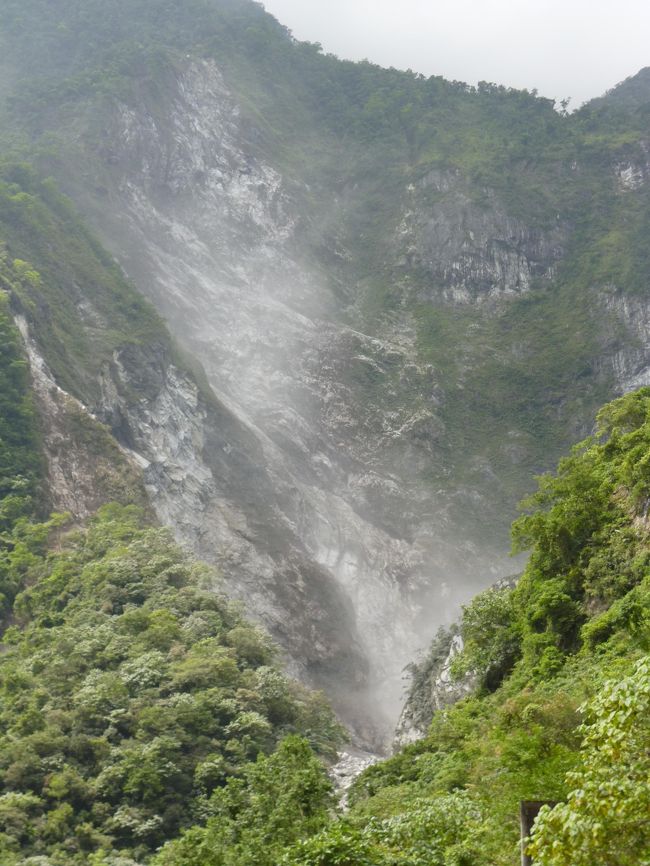 手帳に「昌英飯店」と書いて<br />タクシ−の運転手に渡すと<br />「合点承知」（多分そう言った）<br /><br />ところが太魯閣渓谷のほんのさわりの所で<br />崖崩れ全面通行止め<br />ガガ−ン<br />まんなかの白い煙は岩がゴロゴロの<br />真っ最中の図<br /><br />一体この後どうすればいいのだ<br />運転手は携帯電話持ってない<br />ので道路関係の作業員に彼氏聞くが<br />いつになれば<br />道路通行可能になるのか<br />「岩に聞けって？」<br />3人で協議<br />花蓮に行って観光案内所で<br />今日のネグラとってもらおう<br />全く日頃の行いの悪い奴と旅すると<br />ロクなこと起きない