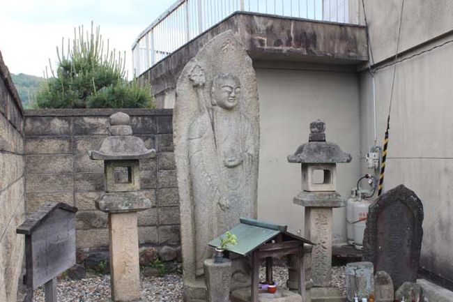 夕日地蔵。<br /><br />西を向いて微笑むように佇む姿から、いつの頃よりか「夕日地蔵」と称されるようになったらしいです<br /><br />「ならざかの　いしのほとけの　おとがひに　こさめながるる　はるはきにけり」　会津八一<br /><br />浅見光彦シリーズ「平城山を越えた女」の舞台になってました<br />ドラマでは右端にヨシズみたいな物が立てかけてありましたね。