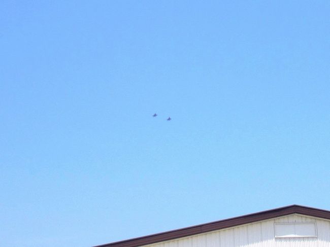 さて、お目当ての戦闘機の飛行展示です！<br /><br />会場内のどこからでも見えるとは思うのですが、たまたま見かけた、なが〜いレンズを付けたカメラを持った人たちの横に陣取りました。<br /><br />予想通り、戦闘機が遠くに見えた瞬間に「来たっ！」とその方向を指さしてくれましたから(笑)<br /><br />めっちゃ小さいのが２機写ってるんですがわかります？<br /><br />『Ｆ−１５Ｊ』という戦闘機だそうです。