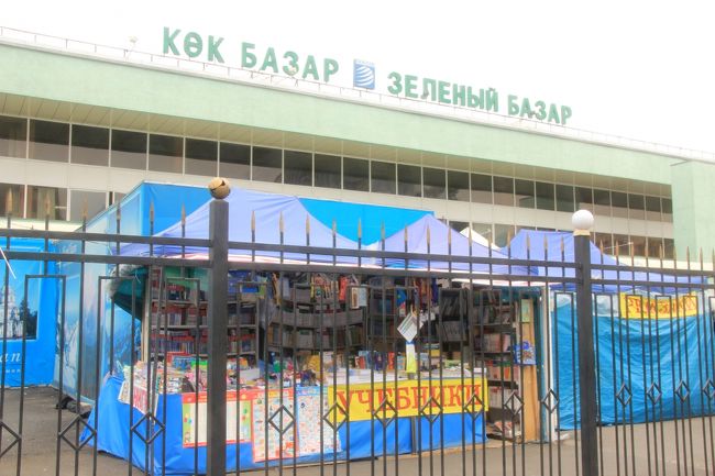 バザールの手前の屋台には文房具屋が並ぶ<br /><br />敷地内に入ったら撮影禁止なので、外から撮りました。<br />豊かな食材がいまのもこぼれそうなほどぎっしり山積みとなったバザールは、見ているだけでわくわくします。<br />肉のエリアで、その場で肉をさばいているところなど、とてもエネルギッシュです。<br />日用雑貨も売られていました。<br />カザフスタンのギフトショップもあったので、少しおみやげを買い足しました。<br />でもあとで気付いたのですが、同じバザール内でも、正門のすぐ手前のカザフみやげ専門屋台の方が全般的に安かったです。<br /><br />「市内のバザール<br />　中央バザールは主に野菜や果物などの食料品が売られていることから、青物バザール（キョク・バザル）とも呼ばれる。中には安い食堂が多い。また北西郊外には、中央アジア最大ともいえる１km以上にまたがる巨大なバザール群バラホールがあり、こちらの方が品数ははるかに多い。（後略）」<br />（「旅行人ノート　シルクロード　中央ユーラシアの国々 [改訂版]」（2006年11月改訂）より）<br /><br />バザールで買い足したものも含めて、今回のおみやげ写真はこちらのハイライト旅行記にまとめました。<br />「2012年中央アジア旅行〜ウズベキスタン・キルギス・カザフスタン〜ハイライトその14：ビシュケクとアルマトイで買ったおみやげ＜ハイライト完＞」<br />http://4travel.jp/traveler/traveler-mami/album/10726267/<br />