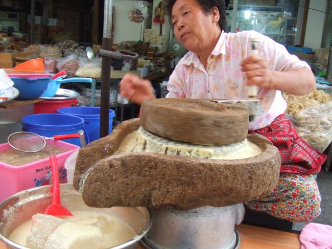 シジャンの道の真ん中におばあちゃんがいました。<br />豆乳を作っているのか、大豆らしきものを石で擂っていました。