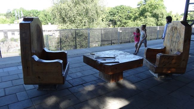 グリーンラインのSkogskyrkog&amp;aring;rden駅。ホームには木製の椅子が。写真を撮っていると向こうから子供が駆けつけあっという間に占領された・・。<br />外に出ると2件の花屋さん。これから行くところは「森の火葬場」という世界遺産。駅から入り口まではゆっくり歩いて5分くらい。日曜の朝でもあり、駅からの人は少なかったけど、韓国人のツアーバスが来ておりました。