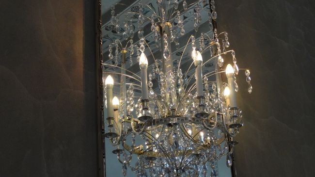 半身のシャンデリアを鏡に移すことによって一つの完全なシャンデリアに見せる。オシャレだ！