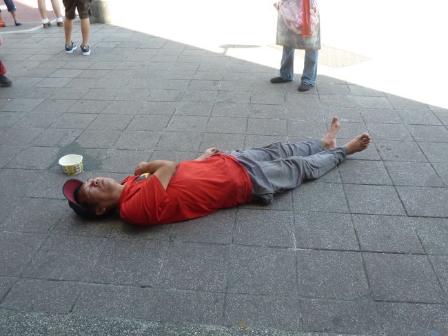 歩道で寝たままで，お金を集めているらしい．日本じゃ大変だね