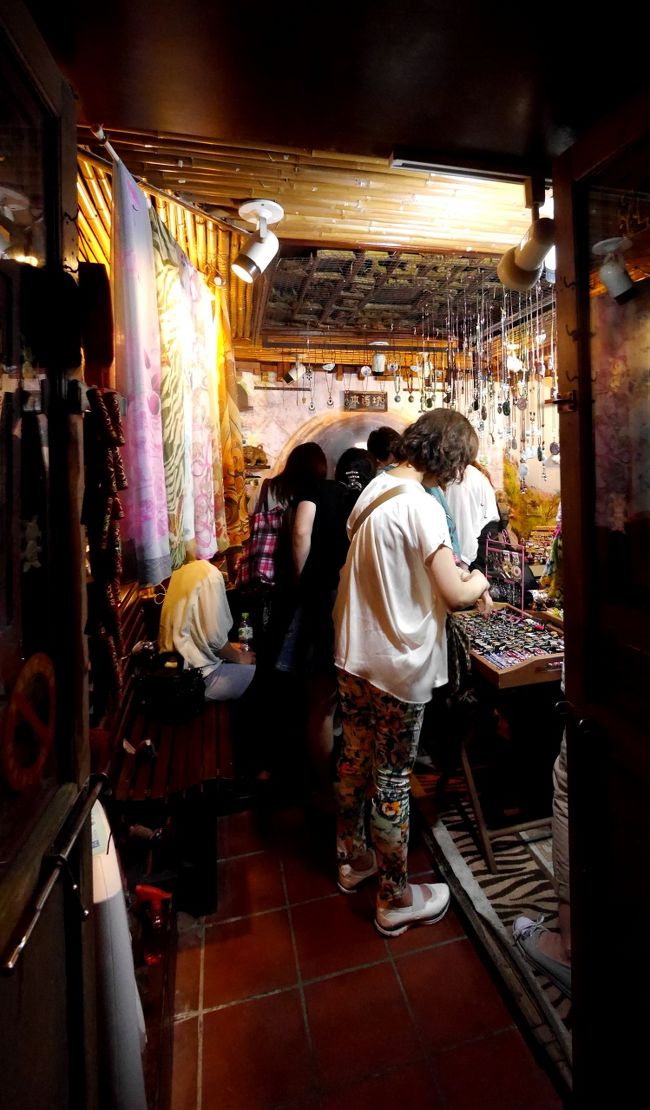 待ち合わせ場所の小さな公園の前のグッズショップ．同僚がお土産を選んでいる