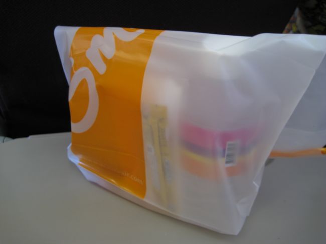 短いフライトだからなのか食事はこういう形で配られた。<br />中には水、パン、コーヒー用ミルクとペーパーナプキン。<br /><br />