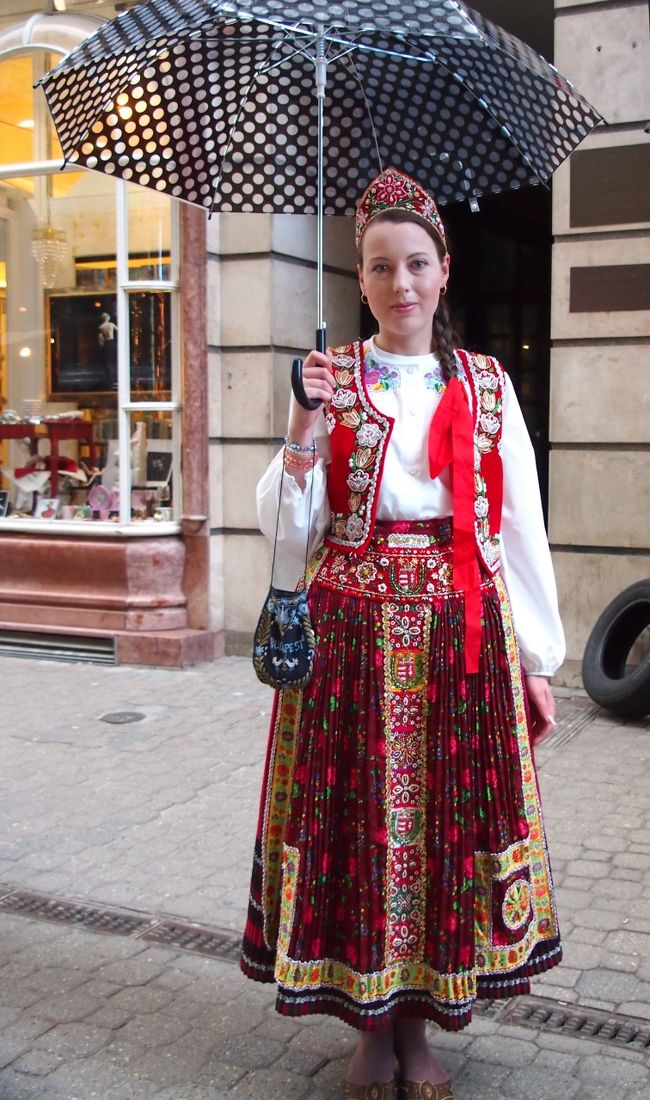 お人形のようにかわいらしい民族衣装のお姉さん・・・早い話が、民族衣装などのお土産品屋の客引きなんですけどね・・・。<br /><br />またちょっと雨がぱらついてきて、傘を差しちゃってるのがホントに残念〜〜！<br /><br />写真撮らせてもらったので、一応お店を覗いて見ましたが、こういう民族衣装・・・買ってもねぇ・・・ざっと見て出てきました。<br /><br />何人かこういう客引きの人いましたが、他はおばちゃんだったりして、きれいなのはこの方だけでしたので、他の人は写しもしませんでした〜〜。