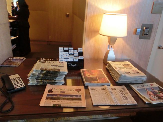 ホテルに戻り、やっとチェックイン。<br />コンシェルジュの隣の机には新聞がいろいろ置いてありました。<br />