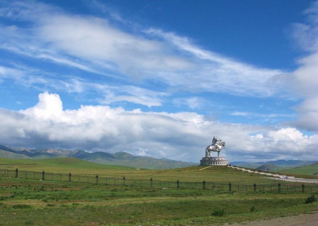 アスファルトの道路に戻っても道はでこぼこで、途中、スピードを緩めて穴や段差を避けながら、注意深くエルデネ村までの一本道を進んでいきます。<br /><br /><br />・・・そして１０時３０分、緑の大草原の小高い丘の上に、陽光を浴びて銀色に光輝く巨大なモニュメントが見えてきました。