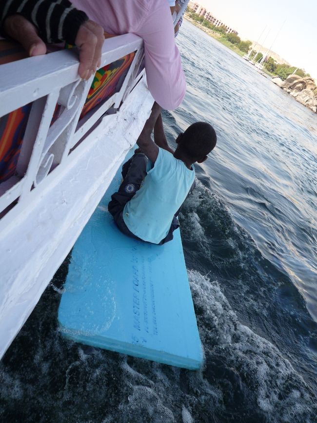 少年がチップや何かを貰いにビート板みたいのに乗って手で漕いで観光客が乗ったファルーカのところに来て歌をうたいます。漕ぐのも、歌も上手！<br />でも貰ったモノで要らないモノはナイル川にポイ捨てしてました(・・;)<br />