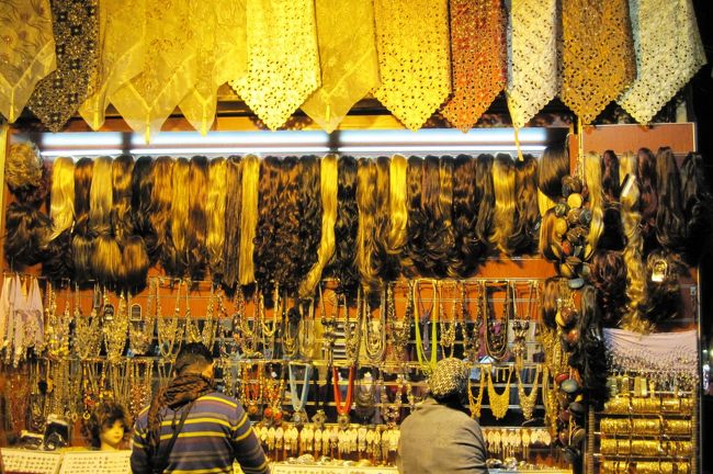 商店街の店先光景です。一番上が情勢のスカーフ、中間辺りが鬘(?)、一番下が装身具などのようです。