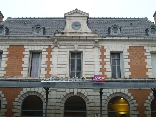 ロデス駅。<br />ここではまず明日の切符、St-Christophe　〜　Figeac までの切符を買わなければいけない。<br />窓口で旅程表を見せ、スタッフの女性は英語を話すので、すぐ購入できた。料金は８．４ユーロ。<br />タクシーについて聞いてみると、１２時頃にコンク行のバスがあるはずだと教えられる。<br /><br />駅の構内には窓口が２つあり、左が列車用で、右がバスの担当らしい。<br />右の窓口に移り、バスの時刻を訊くと、ロデス１２：３０発のコンク行きがあるという。<br />この日は水曜日なので、もしかしたらスクールバスとしてのバスが運行されているかもしれないという淡い期待と、でも学校の休暇に入っているかもしれないし・・と不安要素も想定していた中、うれしい誤算だった。<br />バス料金は７．４ユーロ。タクシーだと１００ユーロ位かと見積もっていたので安堵感でいっぱい。<br /><br />窓口での会話の最中、まさかの日本語を耳にした。同じくコンクに行くという初老の旅慣れた男性の姿。会話こそ弾まなかったものの、不安感が払しょくされた思い。