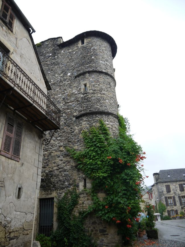 ９番目はサン・トゥラリー・ドルト（Sainte-Eulalie-d'Olt）に行きました。<br />かなり山奥の平地に立地しており、この村も雨が降っていたためか、しっとりと落ち着いた村でした。観光客もそれほどいませんでした。写真は村に入るところにある塔のようなものに見えました。行く途中で郵便車に出会いましたが、フランスでもこんな田舎まで郵便物を配達していました。<br />（駐車場の情報）<br />村の入り口周辺２か所に５０台分くらい。村の近い方は混んでいました。