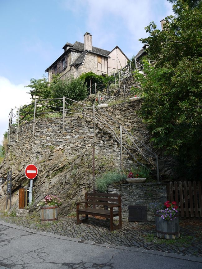 １０番目はコンク（Conques）に行きました。<br />コンクはずっと前から、ミディ地方に来たら必ず行ってみたいと思っていました。期待に違わずとても魅力的な村でした。この村は、スペインのサンティアゴ・デ・コンポステーラに向かう巡礼街道「ル・ビュイの道」の重要な地なためか、他と比べて村も比較的大きかったです。山の中腹に段々に整地して村が形成されていました。<br />村内も整備されており、観光客もとても多かったです。<br />（駐車場の情報）<br />村の下に２０台分くらいありましたが満杯でした。村の上に１５０台くらいでしたが、直ぐに満車になりました。ここは駐車場代が４ユーロでした。