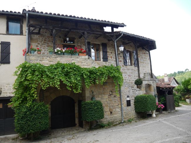 民家の窓に綺麗な花が飾られています。