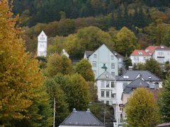 ■ツアー６日目　の続き

フロムからバスで約３時間。やっとベルゲンに着いた。
秋の北欧午後６時過ぎ、あたりはもう薄暗い。
ホテルへのチェックイン＆夕食前に、ブリッゲン地区で約１時間のフリータイム。
バス（写真端っこのピンク）を降りて坂の上の方を見ると　フロイエン山のケーブルカー乗り場がすぐそこに。
他の人はみんな坂を下ってブリッゲン地区へ歩いて行ったが、私は１人でケーブルカー乗り場へ緩やかな坂道を駆け上って行きました。