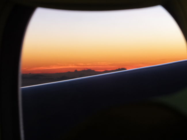 無事に飛行機に乗り込み、すぐに就寝。<br />時間通りに出発しました。<br /><br />朝食のアナウンスで目が覚めると、キレイな朝焼けが見られました。