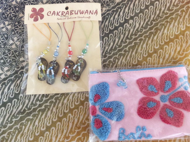 これはバリコレクション内のお土産屋さんで買ったビーサンストラップ＆ミニポーチです。<br /><br />ビーサンストラップは4個入りでRP.50,000、ミニポーチはRP.35,000でした。ポーチにはリップや目薬など、カバンの中で行方不明になりやすい物を入れて使ってます。