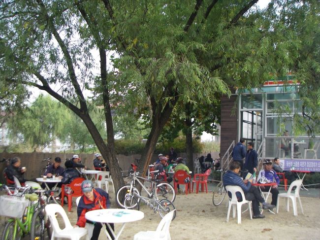 漢江公園　Hangangpark （Gangseo District）<br /><br />河岸の公園にあるコンビニ横にて飲食可能。サイクリストが大勢いて、中にはマッコリ(緑色PETボトル)を飲んでいるおじさん達もいた。<br />歩道走行が可能かなどホテルの周りでまず視察と思っていたが、市街地途中で｢漢江公園｣の漢字表示もあり、案外難しくなく人自転車用出入り口を発見し、漢江河川敷の公園へアクセスできた。　ここからインチョン方面へ(西向き)に自転車道を走る。　<br />｢漢江公園｣には何々地区というような区別があるらしい（でないと何処か判らないから、もっともだが）。<br />