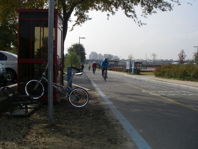 Hangangpark　(Gwangnaru District)　 クァンナル地区　のCertification Center<br />赤い公衆電話ボックスみたいな小屋内にスタンプあり。きれいに押せないので、手製地図上に何度か試みたが、うまくできず。<br /><br />この向こうにクァンナル自転車公園<br />貸し自転車がある公園が幾つかあったが、ここが規模が大きかった。但し、公園で遊ぶには十分だが、長距離走行に向く自転車はなさそう。カップルはタンデムをお奨め(日本には少ないので)<br />