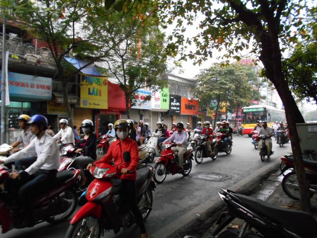 ハノイの町は<br />ホーチミンとは違って<br />緑がとても多いです。<br /><br />そんな中を、マスクで口を覆った<br />ハノイっ子たちはバイクをブンブン言わせていきます。<br /><br />いまは、ちょうど通勤ラッシュ。