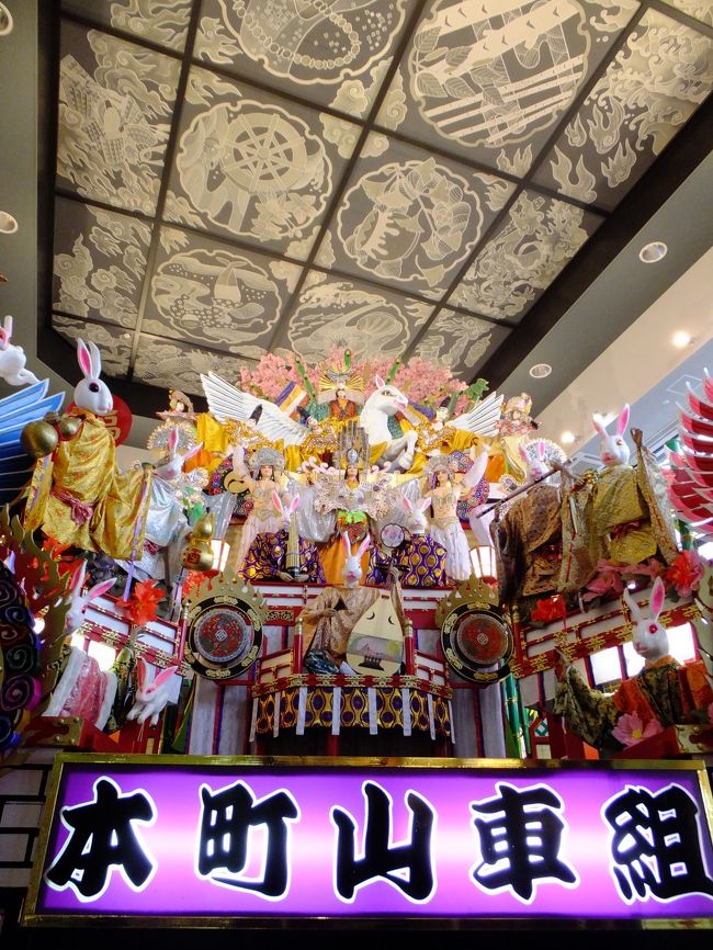 うっわーーすごい！お祭りの山車？？<br />なんかすごい数のいろんなモノが乗ってるんですけど…(笑)<br /><br />写真じゃわかりづらいですが、展示してあるのが２階までの吹き抜けスペースなのでめちゃめちゃ大きいです、コレ。高さはともかく横幅が…フレームに入らない。。。<br /><br />