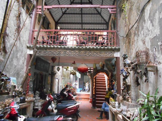 細い通路をず〜っと行ったら<br />なんと、ここは普通の家か？<br /><br />いえいえ、ここが<br />カフェ・フォー・コーのようです。<br /><br />ただブラブラしてるだけのお姉ちゃんが<br />急に立ち上がって、メニューを差し出します。<br /><br />私たちは、ここへ来た目的の<br />「エッグ・コーヒー」とカフェ・スアー・ダーを注文すると<br />エッグ・コーヒーは今日はない、と言われてしまった。<br />仕方なく、かわりに「スア・チュア・カフェ」を注文。<br /><br />席はどこだろうとウロウロしていたら<br />注文したコーヒーを持ってお姉さん登場。<br />席へ案内してくれるのかと思いきや、<br />コーヒーを手渡され、急な階段を指さされた。<br /><br />勝手に上がって行って、好きなところへ座れということらしい。<br /><br />そんなのアリか？