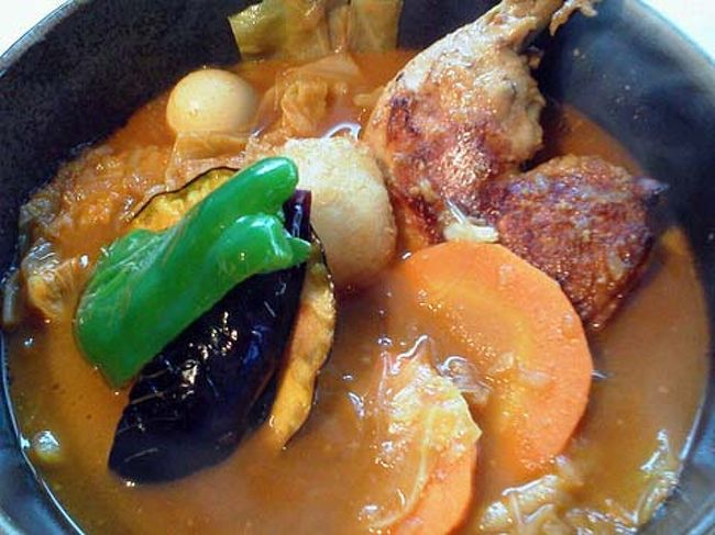 先週、札幌出張した時、<br />山スキーの仲間ＴＮ氏とＹＳ氏と一緒に<br />札幌スープカレーを食べに行きました。<br /><br />私、1996〜1998年まで札幌に勤務していましたが、<br />そのころはスープカレーなるものは、<br />それほどメジャーではありませんでした。<br /><br />名前の通り、普通のカレーにくらべて汁気が多く<br />大きめの具が彩りよく並べられていました。<br />基本の野菜は、蒸されたり素揚げされた<br />ジャガイモ、ニンジン、ピーマン、ナス、カボチャなど。<br />お肉はメニューには、チキンレッグ・豚角煮・ラム・ソーセージなどを選択。<br />スープは、トマト・ベースで各種、スパイスが入っていたようです。<br />ご飯は、スープとは別に出てきます。<br /><br />私、スープをご飯に掛けて食べようとしたら、<br />ＴＮ氏に「エビネンコさん、食べ方がちがいますよ〜」と<br />即、突っ込まれました。<br />「スプーンにご飯をすくって、スープに浸すんですよぉ〜」<br />という教育的指導を受けました。<br /><br />なかなかスパイシーで美味しい。<br />素揚げされた野菜の食感も悪くない。<br />しかし、スープの浸し加減のバランスが悪かったのか<br />スープよりも先にご飯がなくなってしまいました。<br />食べ方、難しいです〜ｗ。<br /><br />私、インドへ３回、行ったことがありますが、<br />特に南インドのカレーは、汁気が多い傾向でした。<br />インド人は、バナナの葉の上で、<br />カレーとご飯を器用に混ぜて食べていました。<br />そのような食べ方をここでやったらどうかな〜と思いましたが、<br />おそらく大迷惑でしょうね。<br />