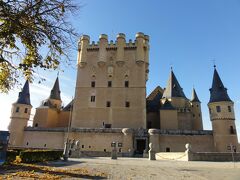 Alcazar de Segovia　アルカサル デ セゴビア　（セゴビア城）に着きました。自然の堀のように三方を川に囲まれ、そそり立った丘の上に建った城塞です。アルカサルが文献に現れるのは、セゴビアがレコンキスタされた直後 12世紀初頭のことですが、現存する建物にカスティージャ王アルフォンソ8世（在位 1158-1214）以前の建築は残っていません。
アルカサルは、中世の歴代カスティージャ王たちが好んで住んだ宮殿であったと同時に、王国における最重要軍事拠点でもありました。
イサベルは1474年12月13日、カスティージャ女王としての戴冠式のために、この城からマヨール広場にあったサン ミゲル教会に向かいました。戴冠式の後、当時はアルカサル前のこの広場にあったカテドラル（大聖堂）でミサを挙げました。
