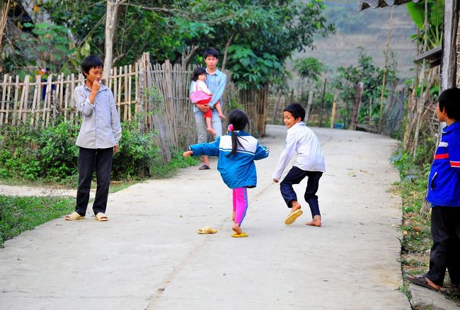 路上で遊ぶ子ども達と、<br />それを見守る親。