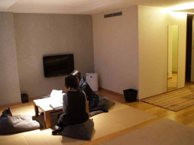 和室部分。娘と妻は、館内案内を見ている。外は真っ暗。