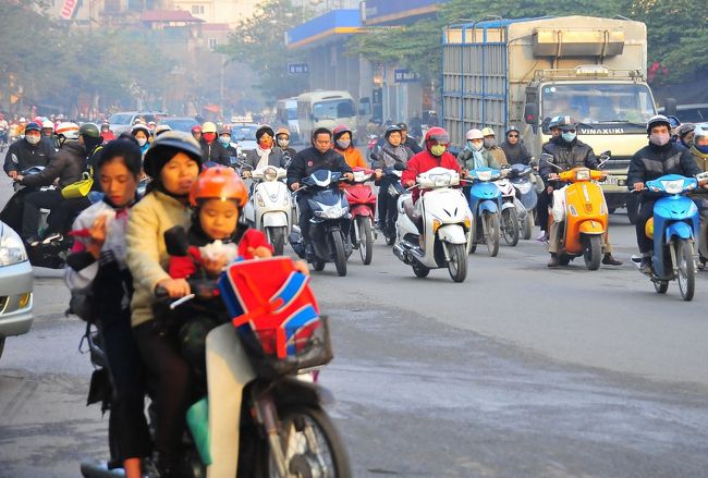３人乗り。<br />前の子は朝食中。<br />おそらく学校に送っていく途中です。<br /><br />その後ろ、男女２人乗りのバイクが、<br />青信号で直進するたくさんのバイクの直前を、<br />あやうく突っ切って行きました。