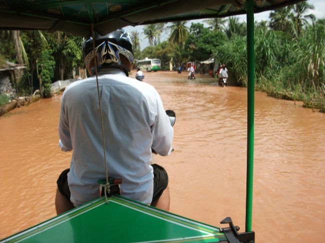 トンレサップ湖の船着き場 → シェムリアップの幹線道路<br />トゥクトゥクの運転手もズボンの裾を捲りあげて、バイクが壊れないように慎重に運転中。