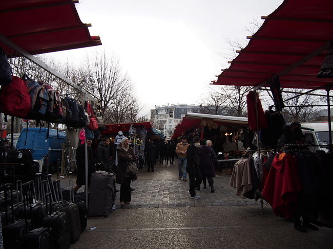 両サイドに見るからに怪しげな(笑)、衣料雑貨店の間を抜け、駅へ戻る。<br /><br />やっぱり片手、低い位置で<br />ナゾのスマホを売る黒人のにーちゃんたち。