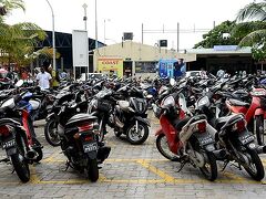 この日の前半行ってみたヴィリンギリ島。
ここはもう、マーレ島に戻って来たあとのマーレ南西ハーバー。

駐車場を埋め尽くすバイクの向こうにマーレ島⇔ヴィリンギリ島を結ぶフェリーのターミナル（黄色い建物）が見えています。

ここで、旦那は用事があるのでタクシーでトレーダーズ・ホテルへ。
SUR SHANGHAIは一人でマーレ島南岸から東岸を徒歩で辿って、同じくトレーダーズ・ホテルを目指します。