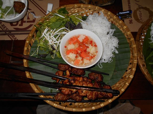 まずは、こちらがブン・チャーです。<br /><br />手前にあるのが<br />黒い箸のようにみえる串に挟まれた<br />焼き肉と、肉団子。<br /><br />真ん中にあるのは、甘酢ダレ。<br /><br />左上がベトナムらしい香草の盛り合わせで<br />そして、右上にあるのが、ブン1人分です。