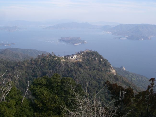 ロープウェイを使っても、20〜30分は歩く必要があります。山頂展望台からロープウェイ山上駅方面の眺め（中央の建物）。<br />