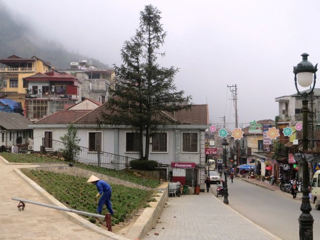 右手が繁華街、左手は広場、・・・、中央には畑仕事のおじさん。<br />