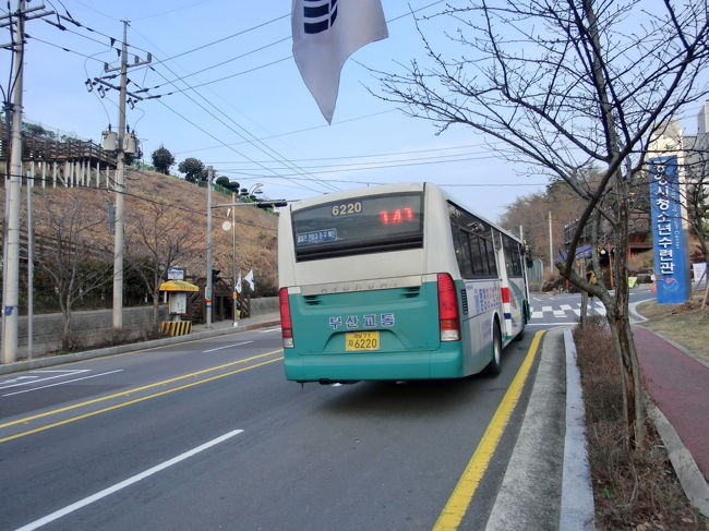 海底トンネル出口に右にゆくとバス通りが見えたので、近くのバス停でロープウェイ乗り場でバスに乗りました。方向が同じなので初めに来たバス（141系統）に乗りました。<br /><br />偶然にも、ロープウェイ入口のバス停に到着。141系統を確認する為、走り去るバスをパチリ