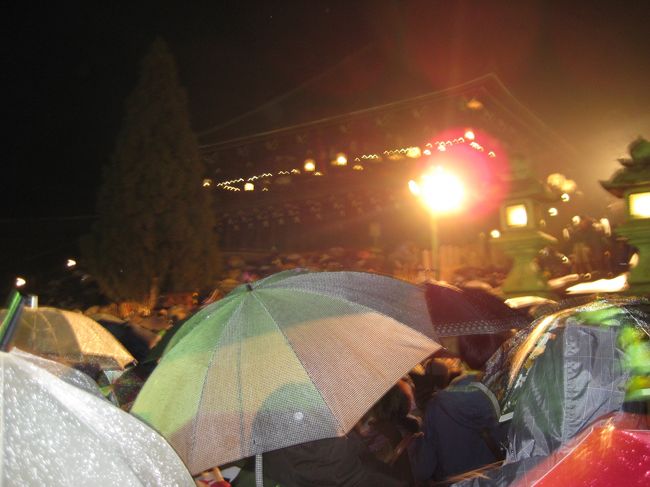 私が初めてお水取りに付いて知ったのは、黛敏郎やシュットクハウゼンらの現代音楽を通してであった。そういった作品中でどんな音響となっていたのかは今となってははっきりしない。ごく最近まで、お水取りという行事の具体的内容は全く知らず、夜中に井戸から水を汲み上げ、読経することかと思っていた。<br />　最近になって、この行事はタイトルとは裏腹に、巨大な松明を掲げて古い木造の寺の廊下を走り回り、火の粉を振り落とすという狂気じみた所業であることを知り、古都の春を先触れする行事ということなので見物しようと思い立ったわけである。<br />　３月１日は初日で午後からしとしとと雨が降り出し気勢がそがれる。それでも５時半にJR奈良駅からバスで出発する。天気のせいか、バスは空いており、道路も平常。東大寺近くのバス停で降りて歩き出してもその印象は変わらなかったが、駐車場のそばを通ると１０数台に登る観光バスの姿、やはり来る人はもう来ているのだ。舞台からはかなり遠くに佇む。ここでは火の粉を浴びる心配はない代わりにご利益もない。<br />　傘を差して待つこと４０分ほど、屋根付きの登り廊下に赤い火が見える。７時に会場を照らしていたライトは全て消された。一斉に傘をたたむ。予想よりはるかに大きい松明の炎が走り出す。木の燃える芳香も漂ってくる。聞こえてくる掛け声、床を踏み鳴らす音が、ちょうど歌舞伎の間を詰めていくリズムで響く。人によっては太鼓のようにも聞こえたらしい。舞台の右端に到達した松明は屋根よりも高く掲げられ、やがて突き出されクルクル回されて、下に火の粉を撒き散らす。それは決して細かなものではなく、落ちてもしばらく燃えているほどで、直接受けるとかなり危険に思える。やがて左端から次の松明が出現する。火の散り方は１本ずつ違い、前のものより見事だと歓声が上がる。<br />　私は写真を取り続けた。しかし小型デジカメではうまくいかなかった。軽すぎるためしっかり構えることができないし、ストロボは遠すぎて届かず、近くの広げられた傘ばかりが鮮明に映る。肝心の炎や松明は流れてしまい、手ぶれも加わってパソコンに入れても全てゴミ箱行きと相成った。重さを忌避して、一眼レフを持ってこなかったことを後悔。<br />　30分ほどして１０本目の松明が燃え尽きるとお開きとなり、ライトが点灯され、警察の「ゆっくり帰れ」という放送が流れる。多くの人はまだ何かを期待してか、すぐには立ち去らない。私は、はじにいたせいもあり、すぐに雑踏を後にし、東大寺の境内を抜けると、臨時バスが待っていて素早く帰還することができた。<br />