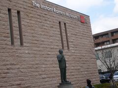 阪急電車で梅田駅より２０分で池田駅に到着。

駅より徒歩５分で「インスタントラーメン発明記念館」です！

きれいな建物で、安藤百福（あんどう　ももふく）氏の銅像がお出迎え。