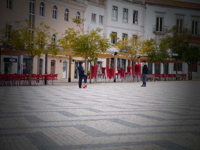 広場でサッカーする少年。