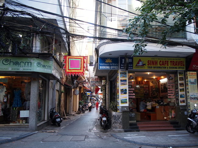 馴れないハノイの街<br />道に迷ってホテルに戻れなくなると<br />困るので、路地の入り口を撮った<br /><br />意味不明だが<br />この四角い旗が目印になって<br />いちども迷わなかったよ<br /><br />ベトナムには『シンカフェ』という<br />古参の大手旅行社がある<br />今は名称変わって『シンツーリスト』<br /><br />オープンバスなど便利なサービスを<br />いっぱいやってるけど<br />どうやらニセの『シンカフェ』が多いらしい<br />この路地右角のお店も<br />似て非なる別の旅行社<br /><br />ちなみに本物はこちら<br />The Sinh Tourist<br />https://www.thesinhtourist.vn/<br />