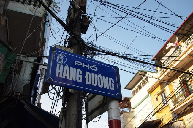 ベトナムの街では<br />通りの名前の標識はよく整備されている<br />日本よりわかりやすい<br /><br />この標識<br /><br />　Pho' Hang Duong<br /><br />google先生に聞いてみると<br />　Pho は street<br />　Duong も street　とでてきた<br />意味がよく分からないので<br />友だちのベトナム女子に聞いてみたら<br />いろいろ教えてくれた<br /><br />まず、<br />"duong"　は大きなstreet<br />"pho^'"　は小さなstreet<br />ハノイのold quarter地域は<br />どれも狭いので、地元の人はphoと呼ぶ<br /><br />さらに、<br />duong はstreetという意味のほかに<br />『砂糖』といいう意味もある<br /><br />むかし、この通りでは<br />砂糖や砂糖菓子を売ってたので<br />その名前になったそうだ<br /><br />ちなみに、<br />old quarterには36のstreetがあって<br />それぞれ違うものを売っていた<br />たとえば、Hang gaというところでは<br />ga（鶏）を売っていたんだって<br /><br />大阪の街の名前も同じようなのがあるよね