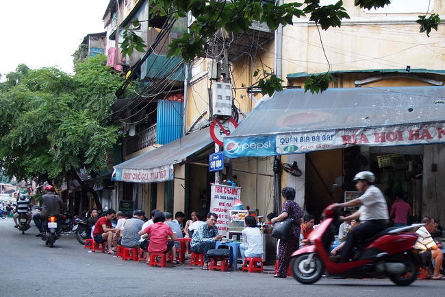 まるでお風呂の椅子のような<br />小さい椅子に座って<br />コーヒーや紅茶（リプトンと言う）とか<br />マンゴージュースとか飲んでる<br /><br />そう、これはベトナムでは<br />どこでも見かけるカフェテラス<br /><br />最初、見たときは<br />なんだか可笑しく感じたけど<br />街を歩いてるとどこでも見かけるので<br />なんとも思わなくなっちゃった（笑）<br /><br />ぼくもなんどかこういうカフェで<br />ベトナムコーヒーとか飲んだけど<br />この低い位置に座るって<br />けっこう落ち着けるんだよね<br /><br />この種のカフェには<br />お風呂の椅子タイプのお店と<br />背もたれ付きの椅子（背は低い）のお店の<br />２種類があって、どちらも楽しいよ<br />