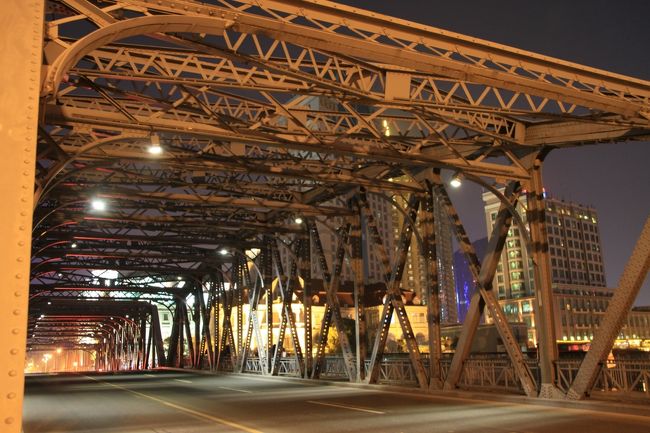 ○　外白渡橋<br /><br />外白渡橋（Garden Bridge of Shanghai）は、蘇州河下流の黄浦江との合流地点に位置する鉄橋。中国で最初にできた全鋼構造の橋であり、中国に唯一現存する不等高桁橋。<br /><br />初代外白渡橋は1856年に建設された、「威爾斯橋」という木造の橋でした。威爾斯橋は、怡和洋行の英国人威爾斯と宝順洋行の韋丈}、霍梅ら20名（そのほとんどが洋行経理もしくはアヘン販売の元締め）が共同出資して設立した「蘇州河橋梁公司」（中国初の橋梁建設をメインにした会社）が投資して建てられました。橋の長さは137.25m、幅7.015m。真ん中は可動式で、船が通る時に吊りあげて使用していました。威爾斯は、上海道台から「橋の通過税」の徴収を許可された、と主張。中国人のみから通行税を徴収し、外国車両や傭人の通行税を免除したことから、上海住民の怒りを買いました。その後、広東人の勝且瘠・ｪ現在の山西路の交差点に、船着き場をつくったことから、中国人も無料で行き来できるようになりました。中国人も「ただで渡れる」ようになっため、白渡（ここでいう「白」は「無料」の意味）と呼ばれるようになったといわれています。<br /><br />それでも租界工部局は民衆の怒りをおさえきれず、1876年威爾斯橋の近くに通行税が無料の木製の浮橋を建設しました。この橋は外灘公園の近くにあったため、「公園橋」と名付けられました。そしてこのときから、橋を渡るのが無料になったため、「外白渡橋」と呼ばれるようになりました。その後、威爾斯橋は工部局に買収され、解体されました。光緒年間になると、何度も修復作業を受けた木造の橋は、交通の需要にそぐわないという理由で、工部局により鉄橋に建て替えられました。鉄橋が完成してから40年以上もの間、一度も大きな改修工事は行われていませんでしたが、1945年戦争に勝利すると、橋の台の下部分に亀裂が入っているのが発見され、コンクリートで修理がなされました。戦後は、何度か点検が行われ、大がかりな修理作業が9度行われています。