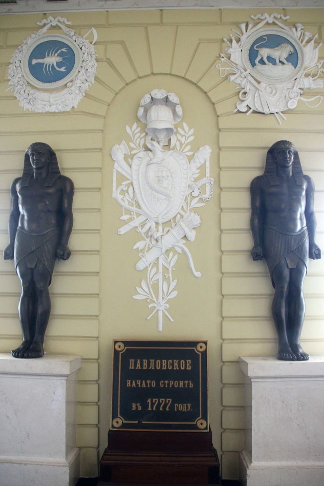 階段を上る前も見学対象なので忘れずに<br /><br />係員に、さあ、見学はこちらよ、と階段に上るように促されますが、忘れてはなりません、階段を上る前は１年を象徴する12の銅像（どれも古代エジプト人の彫像に見えましたが……）と十二宮のシンボルで飾られた「「エジプトの玄関」です。<br />写真は、蠍座と獅子座のシンボル。<br />1777年は宮殿の建築年。<br />